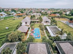 an aerial view of houses and pool in the middle of a lush green area with palm trees