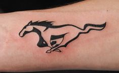 a black and white horse tattoo on the left arm, with an outline of a running horse