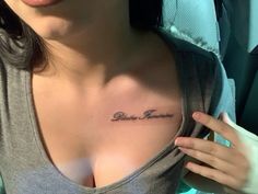 a woman with a small tattoo on her chest and the word love is in cursive writing