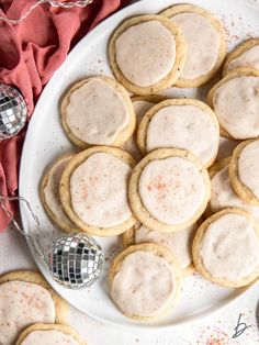 a plate full of cookies with frosting on them and disco balls in the background