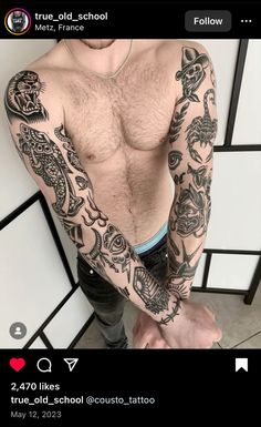 a man with tattoos on his arm and chest is taking a selfie in the mirror