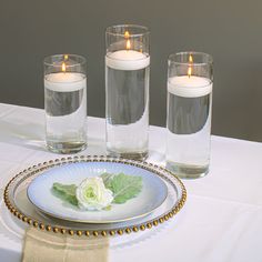 three candles are lit on a plate with flowers