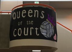 a sign hanging from the side of a building that says queens of the court on it