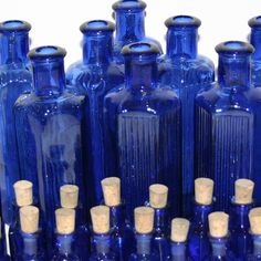 several blue glass bottles with corks in them