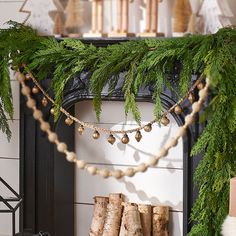 a fireplace decorated for christmas with pine cones and garland