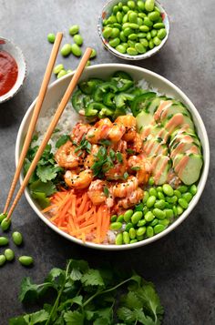 a bowl filled with rice and vegetables next to chopsticks