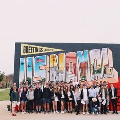 a group of people standing in front of a mural