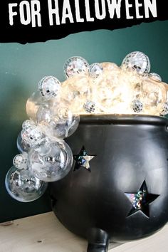 a black caulder filled with lots of clear bubbley balls on top of a table