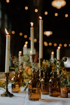 several vases with flowers and candles on a table