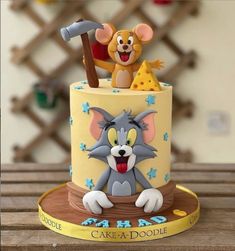 a cake with a cartoon character on it and a mouse figurine next to it