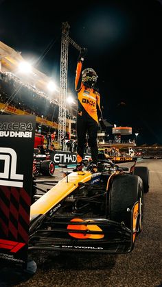 a man standing on top of a race car