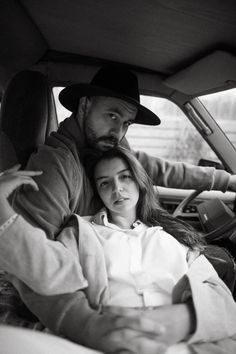 a man and woman sitting in the back seat of a car