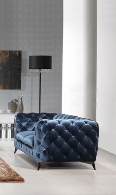 a living room with a blue couch and lamp on the side table in front of it