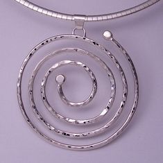 "One-Of-A Kind 'circle of life' pendant    The 'Circle of Life' spiral pendant is wrought by hand from solid sterling silver. The entire 'circle of life' spiral pendant is constructed from one continuous length of hammer textured silver, the back high polished and the edges diamond burred to a satiny finish. 'Circle of Life' makes a great and fun statement piece (given its undulating 'sparkles'!).The 'Circle of Life' Pendant measures approximately 52 mm in diameter and weighs a total of 12.5 gra Life Spiral, Spiral Pendant, Infinity Heart, Handmade Wire Jewelry, Circle Of Life, Handmade Wire, Custom Jewelry Design, Wire Jewelry, Sterling Silver Pendants