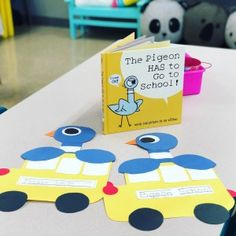 a yellow book sitting on top of a table next to some cut out paper cars