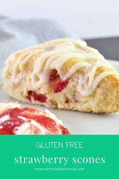 two scones with icing and strawberries on a plate