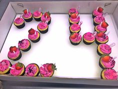 cupcakes with pink frosting and strawberries are arranged in the shape of the letter u