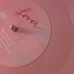 a pink record with the word love written on it's side and a small metal ball at the top