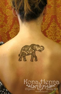 an elephant tattoo on the back of a woman's upper arm and shoulder,