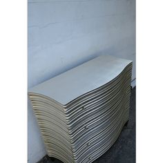 a stack of metal sheets sitting in front of a white wall