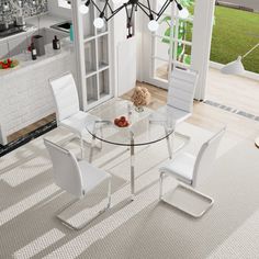 a glass table with four white chairs around it in a room that has an open floor plan