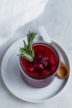 a white plate topped with a bowl of cranberry sauce