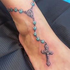 a foot with a cross and beads on it