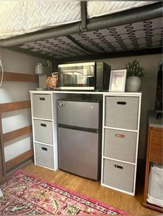 a refrigerator freezer sitting inside of a kitchen next to a microwave on top of a cabinet