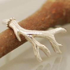 We are excited to introduce THE BAILEY! We worked with an amazing artisan out of California to make this handmade beauty. This ring features a solid, beautifully toned Sterling Silver Antler twig branch. This band is hand-formed from a sheet of sterling silver and wire to create a stunning authentic design. ABOUT THIS RING Metal: Sterling Silver Color/Finish: Silver, Polished QUESTIONS ABOUT SIZING Go to our Ring Sizing Guide for details and important guidance. CARE INSTRUCTIONS SPECIFIC TO THIS Rustic Bridesmaids, Antler Wedding Band, Deer Antler Ring, Twig Branch, Antler Ring, Branch Ring, Engagement Ring For Her, Engagement Sets, Handmade Beauty Products