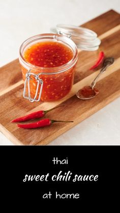 a wooden cutting board topped with a jar of chili sauce