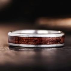 a wedding band with wood inlays sits on a table