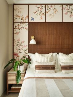 a bed with pillows and two planters on the headboard in front of it