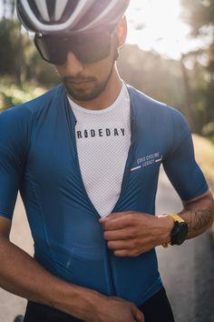 a man wearing a bike helmet while standing next to a road