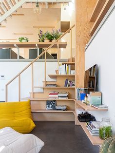 a living room filled with lots of furniture next to a stair case and bookshelf