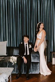 a man and woman posing for a photo in front of a couch