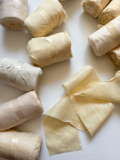 several pieces of rolled up food sitting on top of a white surface with one piece torn off