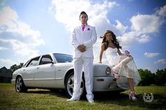 a man and woman standing next to a white car