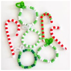 several bracelets made out of candy canes on a white surface with green, red and white beads