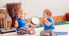 two toddlers sitting on the floor playing with a magnifying glass in front of them