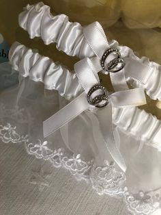 Beautiful garters with shiny double ring decor.  One garter is adjustable to XL.  The other is the "toss" garter. Both are white satin with bow.  Bride's garter has lovely lace with embroidered edge. Bride Garter, Wedding Sash Belt, Jupiter Fl, Wedding Belts, Double Ring, Garters, White Satin, Wedding Accessories, Belts