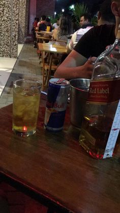 a man sitting at a table with two drinks in front of him