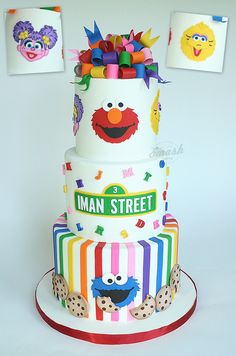 a three tiered cake decorated with sesame street characters and clown faces on it's sides