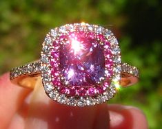 A beautiful and sparkly engagement ring featuring an amazing pink sapphire, surrounded by more pink sapphires, in a rose gold diamond double halo. The center stone is a beautiful precision-cut cushion pink sapphire, measuring 1.88 carats and 6.9x6.3mm. It is basic heat and comes from Madagascar. It has a juicy pink color, clean crystal and crazy sparkle (be sure to check the video). Great choice for a one-of-a-kind engagement ring! The sapphire is set in a 14K rose gold diamond double-halo ring, Luxury Pink Halo Ring For Wedding, Gia Certified Cushion Cut Pink Ring, Luxury Pink Halo Design Jewelry, Pink Halo Ring In Fine Jewelry Style, Pink Sapphire Jewelry With Halo Design, Pink Halo Ring Fine Jewelry, Luxury Pink Halo Ring For Gift, Luxury Pink Halo Ring As Gift, Luxury Pink Halo Jewelry