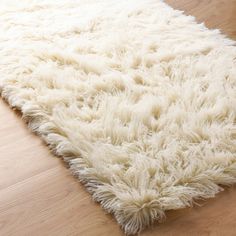 a white rug on top of a wooden floor