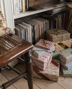 many boxes are stacked on top of each other in front of a bookshelf