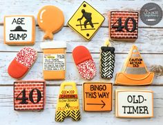 decorated cookies are arranged in the shape of road signs and construction hats on a white wooden surface