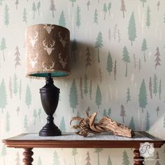 a lamp sitting on top of a wooden table next to a wallpapered wall