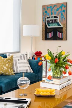 a living room filled with furniture and a vase full of flowers on top of a coffee table