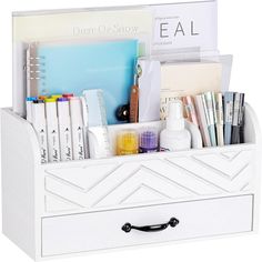 a white desk organizer with books, pens and other office supplies in the bottom drawer