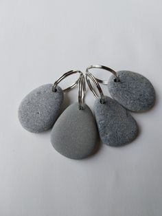 four stone keychains with metal rings attached to them on a white table top